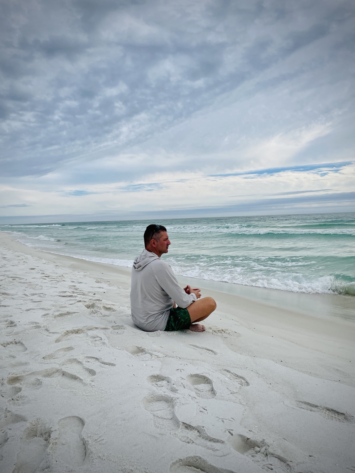 Doychin sitting quietly on a beach, looking toward the sea